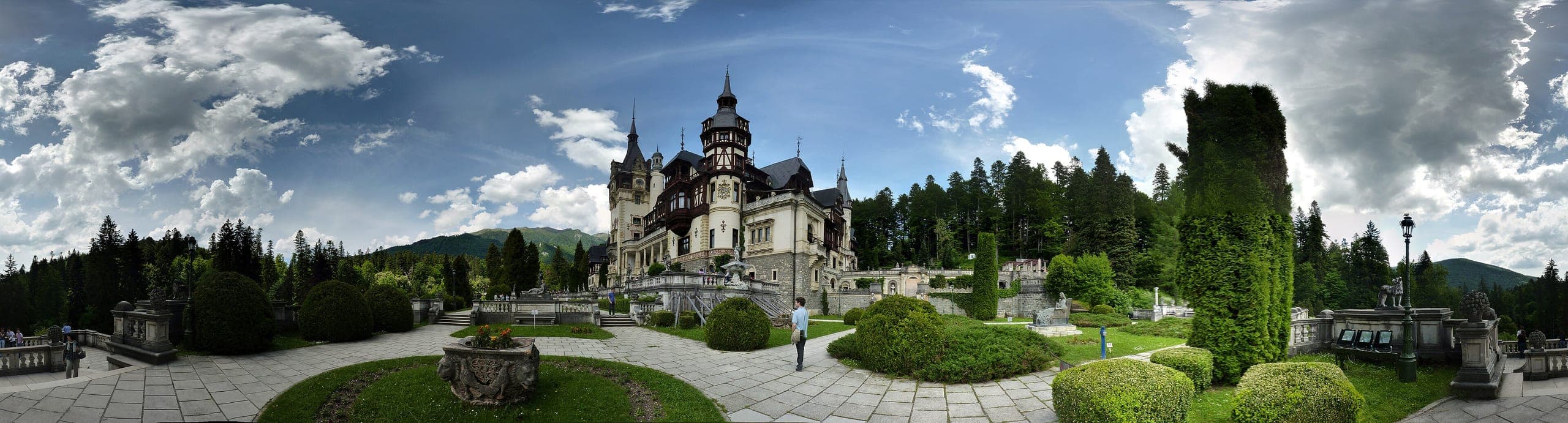 Peleș Castle against the Carpathian mountains at dusk